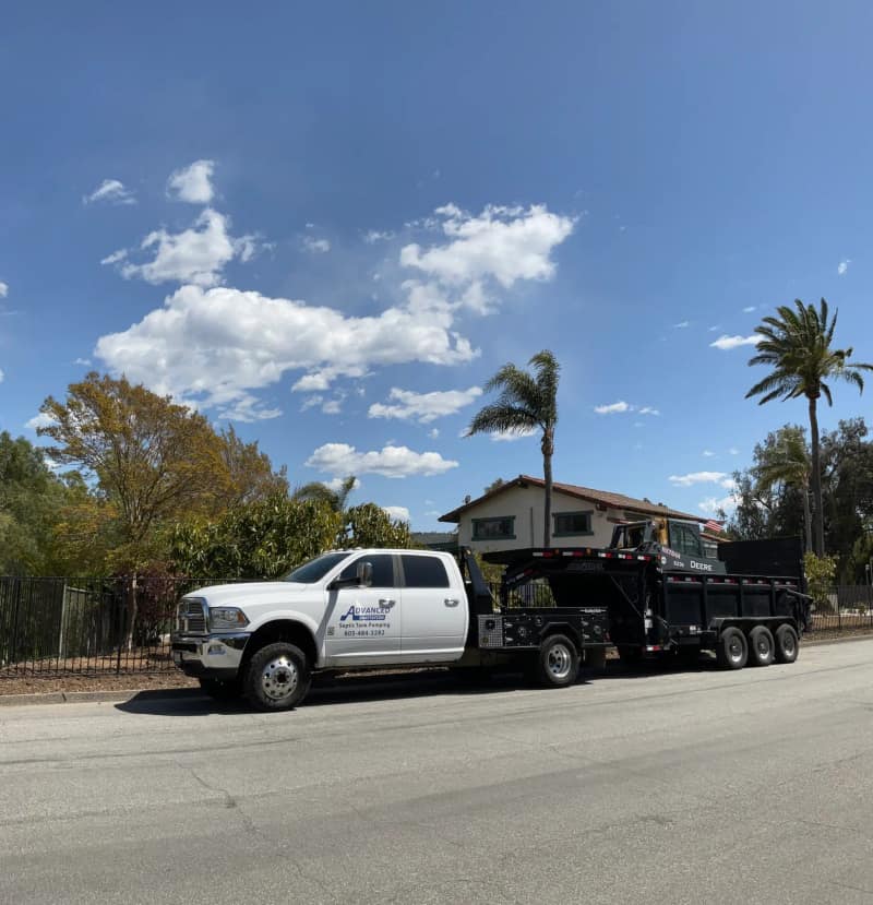 White service pickup with an equipment trailer parked on a palm-lined street