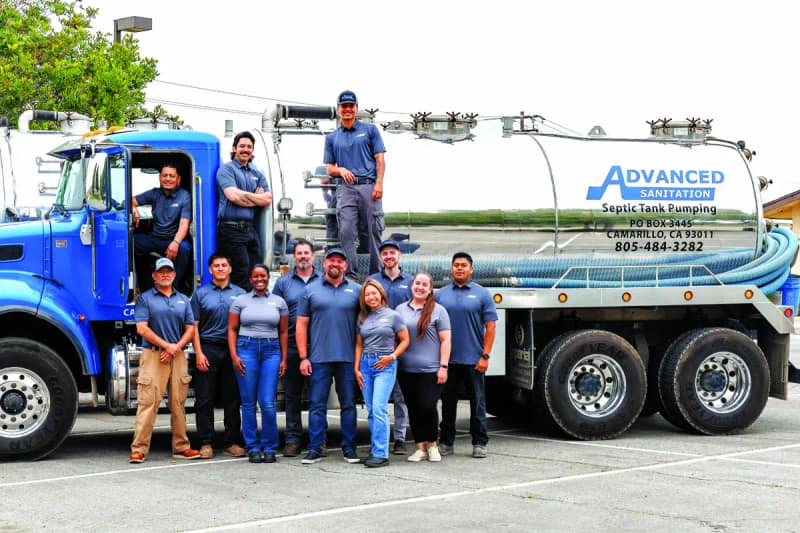 Advanced Sanitation crew and office staff lined up in front of a pump truck