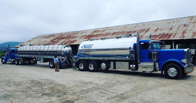 Blue tractor truck hauling a long polished tanker trailer